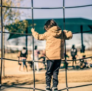 Young child on rope structure in a playground